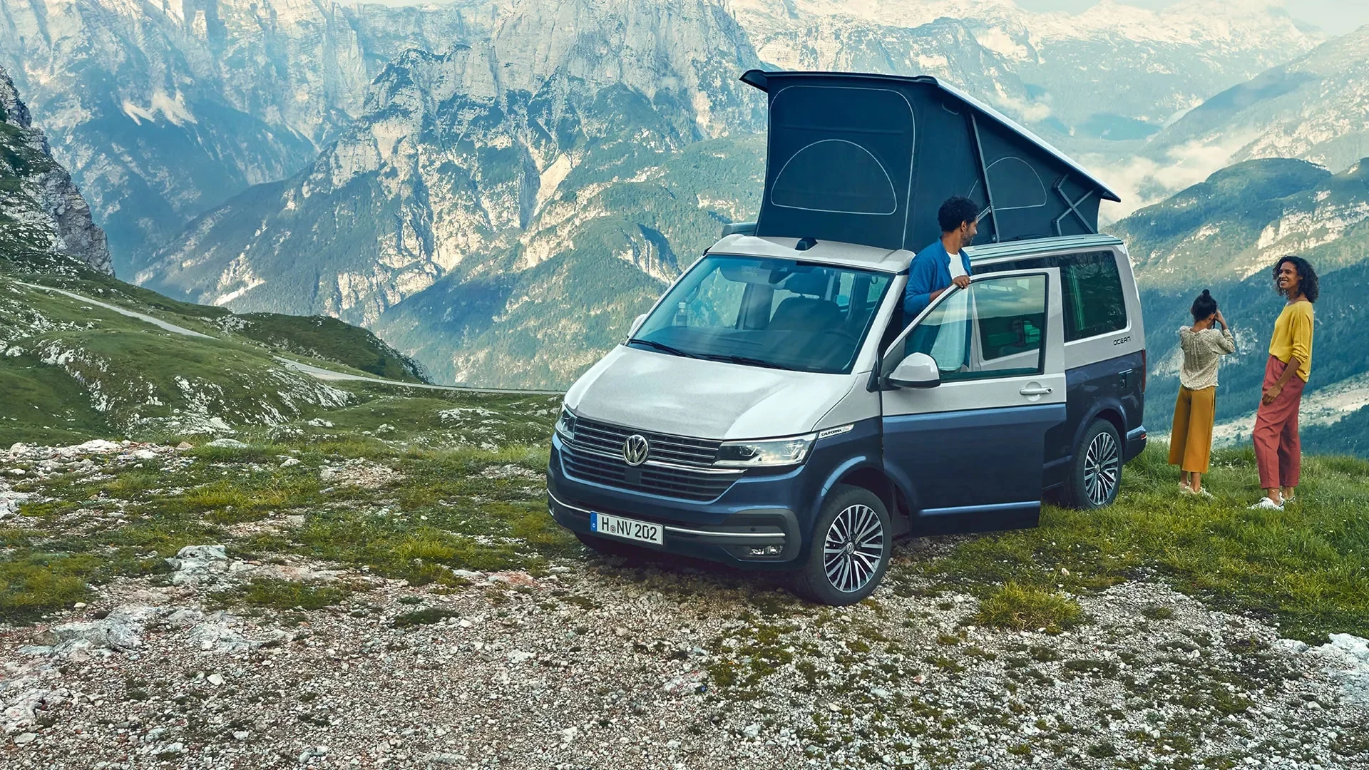 Campen in den Bergen: Blick auf den Volkswagen Kalifornia sowie sein ausgefahrenes Dach-Zelt