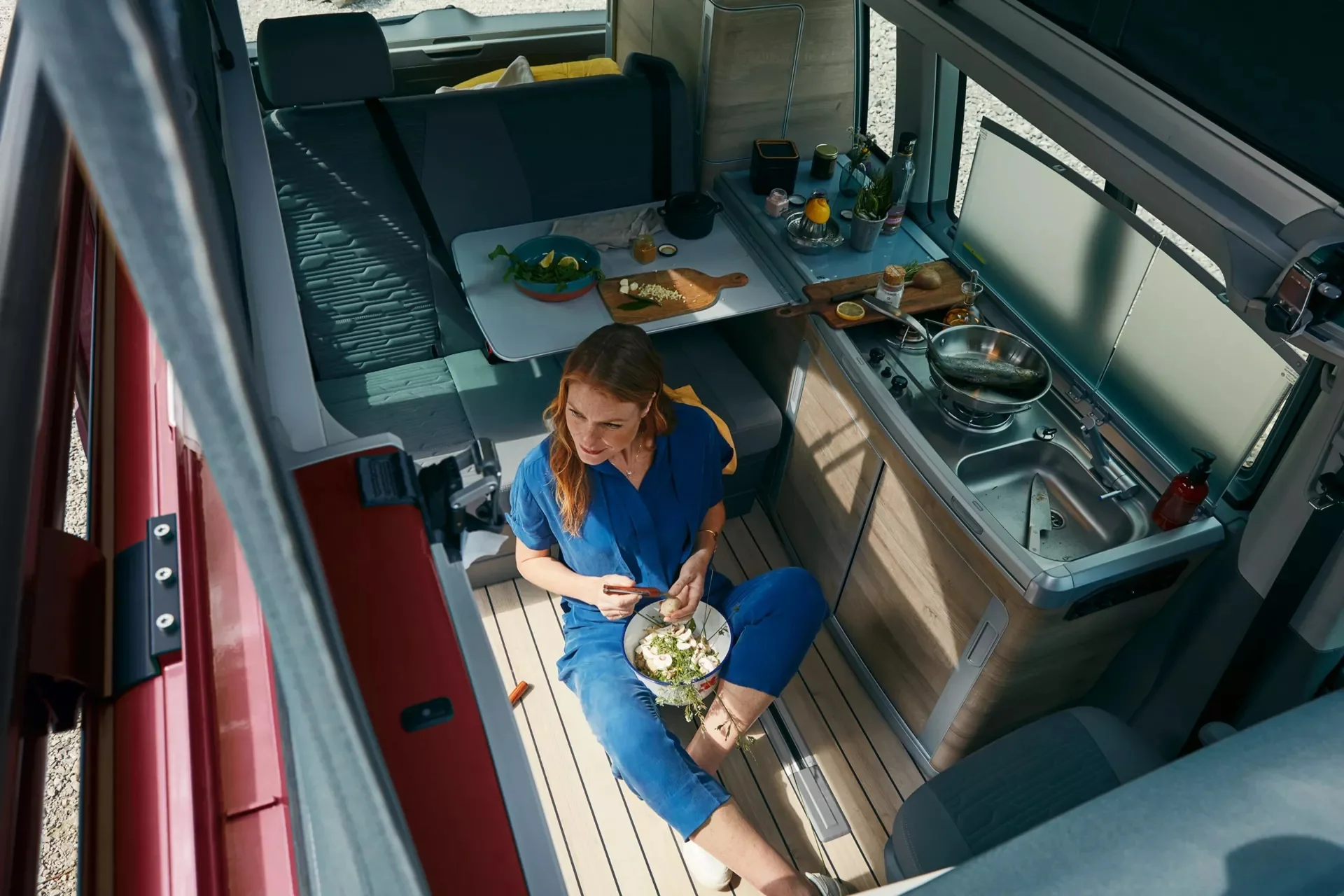 Das geräumige Interior des VW California mit Küchenzeile, Sitzbank und Tisch