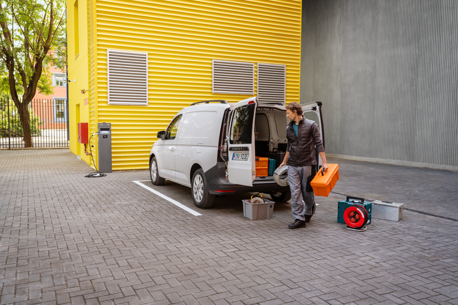 Der Caddy Cargo im Arbeitsalltag: ein Handwerker vor der geräumigen Ladefläche